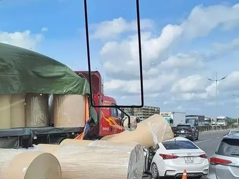 Nhiều cuộn giấy trên xe đầu kéo rơi xuống đường, đè trúng ô tô con